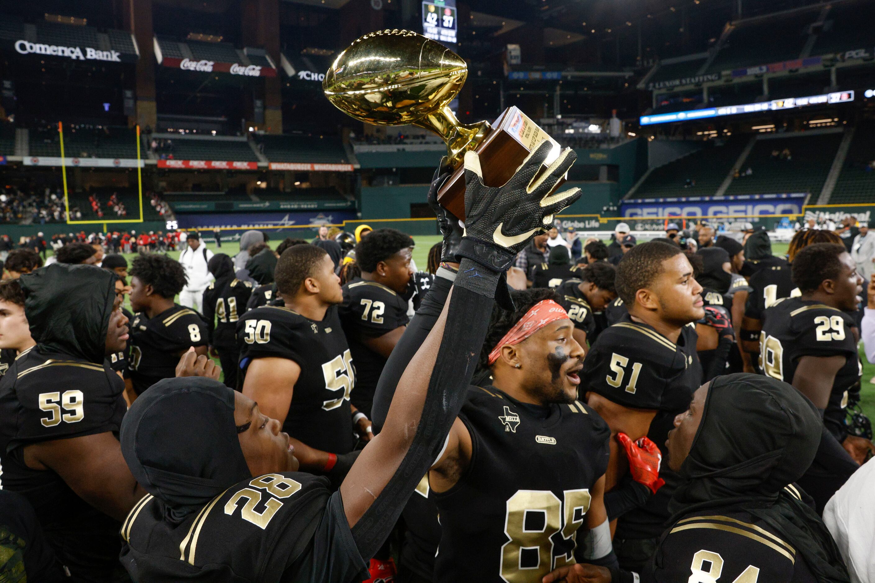 South Oak Cliff players raise the area round trophy after a Class 5A Division II area-round...