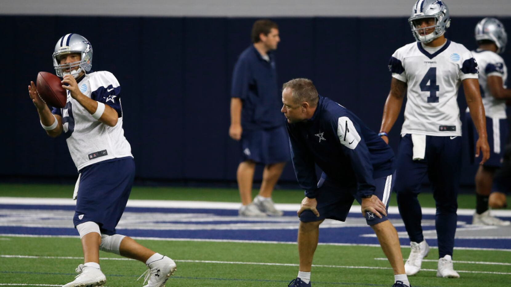 Cowboys quarterback Dak Prescott (4) watches quarterback Tony Romo (9) getting a snap during...