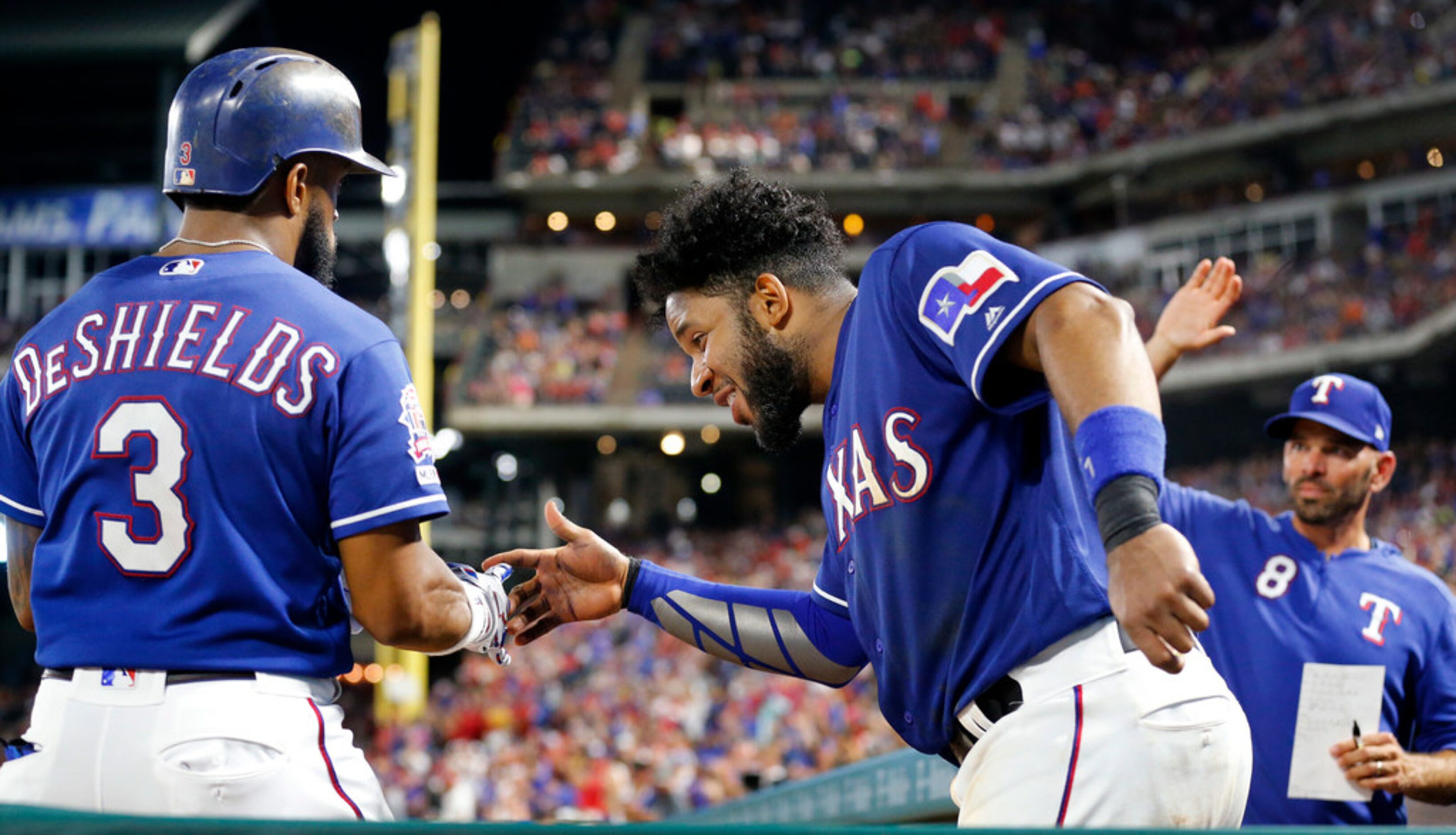 Texas Rangers Delino DeShields (left) is congratulated by teammate Elvis Andrus after...