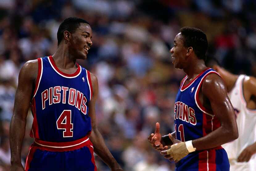 Joe Dumars #4 and Isiah Thomas #11 of the Detroit Pistons talk things over on the court in...