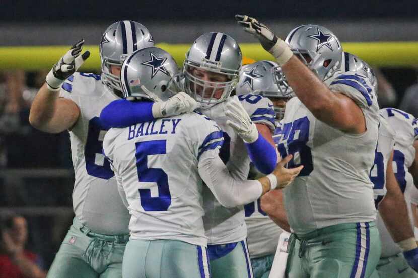Dallas Cowboys tight end Jason Witten (82) and other teammates hug kicker Dan Bailey (5)...