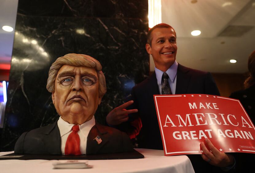 An attendee stood for a photograph with a cake in the likeness of Donald Trump at an...