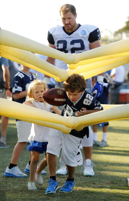 Dallas Cowboys tight end Jason Witten (82) watches as his kids Cooper and Hadley run through...