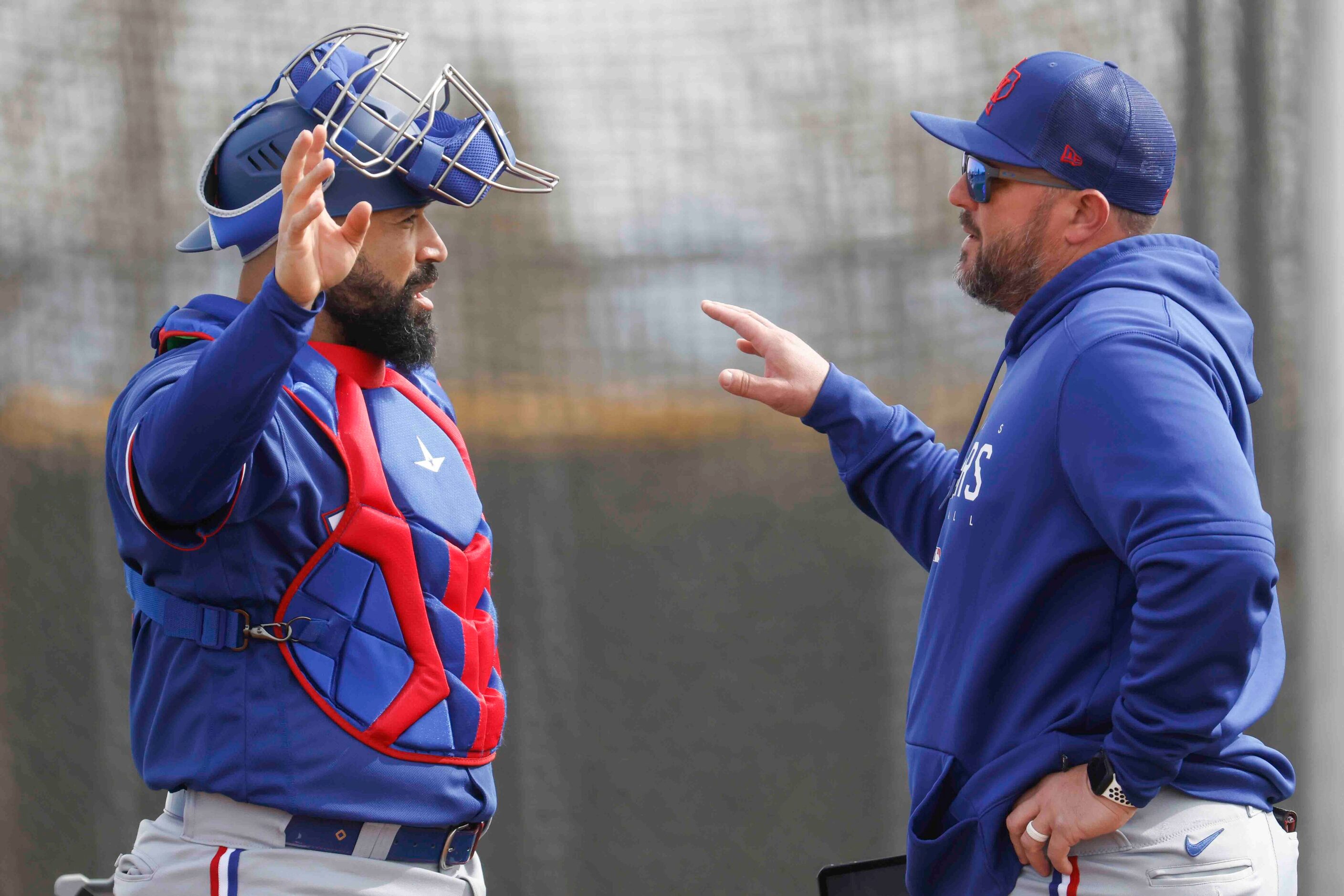 Texas Rangers catcher Sandy León, left, talks to catching coach Bobby Wilson during a spring...