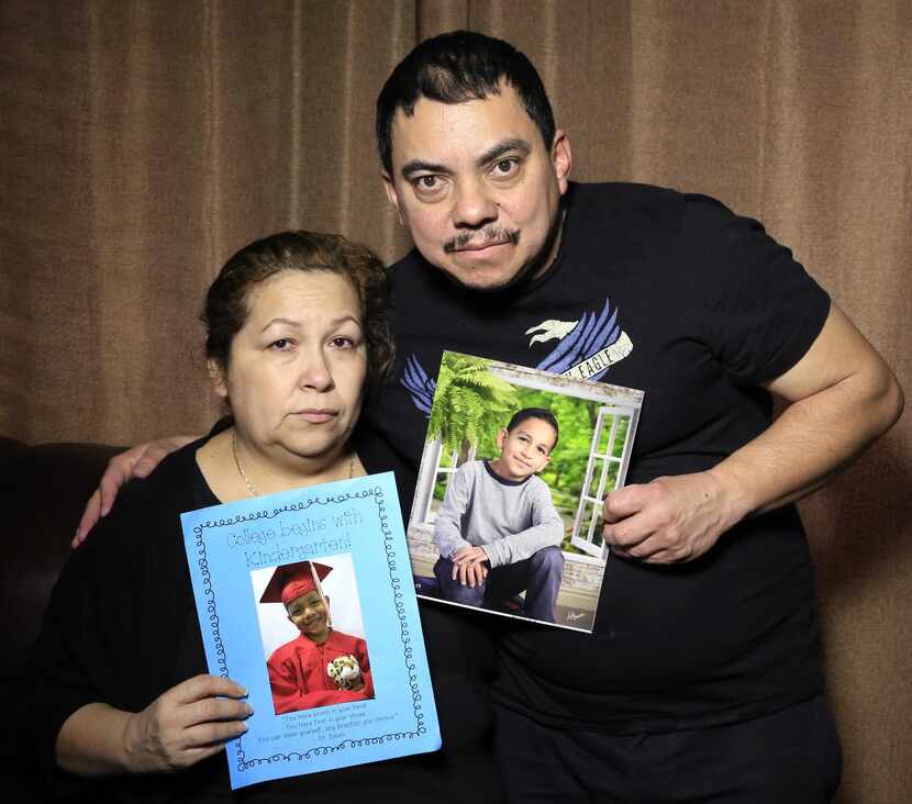 Melva Medina y su esposo David sostienen fotografías de sus nietos, Kenneth y César...