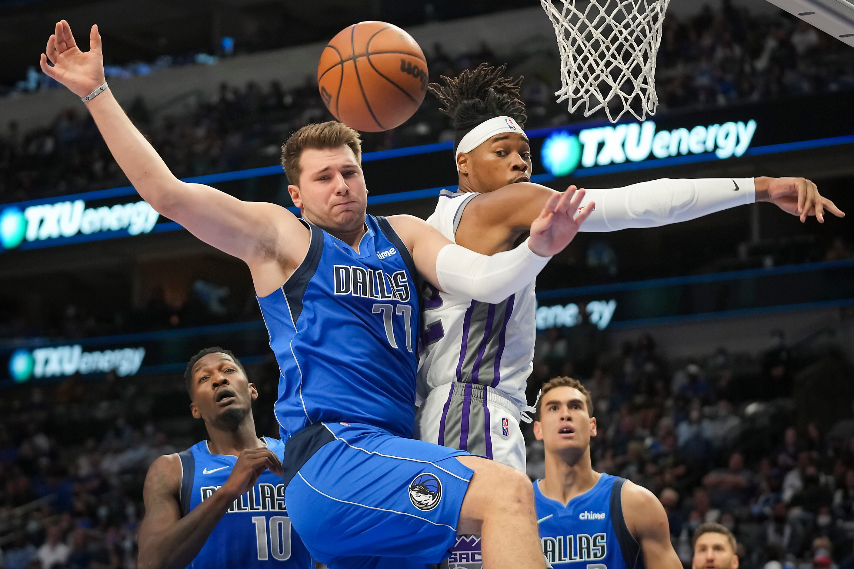 Dallas Mavericks guard Luka Doncic (77) fights for a rebound against Sacramento Kings center...