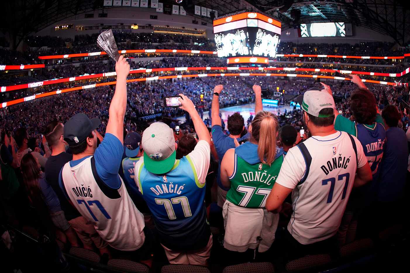 Dallas Mavericks fans, all wearing guard Luka Doncic #77 jerseys, cheer as their team takes...