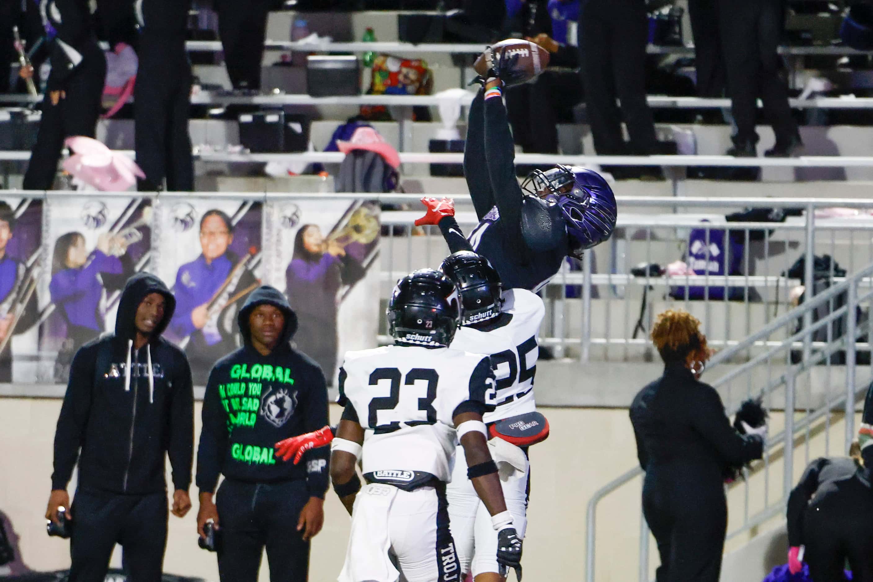 Crowley High’s Jacque Overton (top) jumps to receive a pass for a touchdown past Trinity...