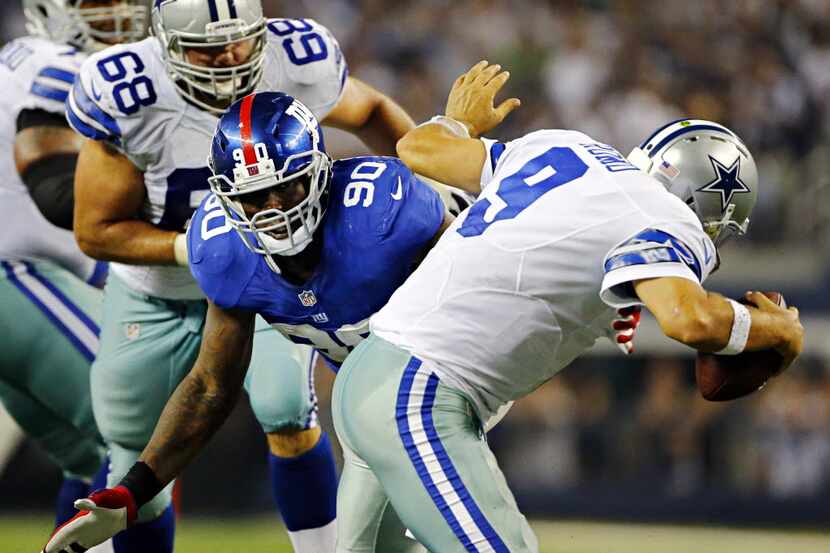 Dallas Cowboys quarterback Tony Romo (9) is brought down by New York Giants defensive end...