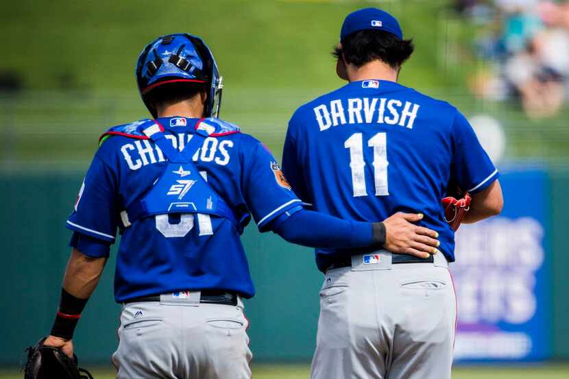 Texas Rangers catcher Robinson Chirinos (61) consults with starting pitcher Yu Darvish (11)...