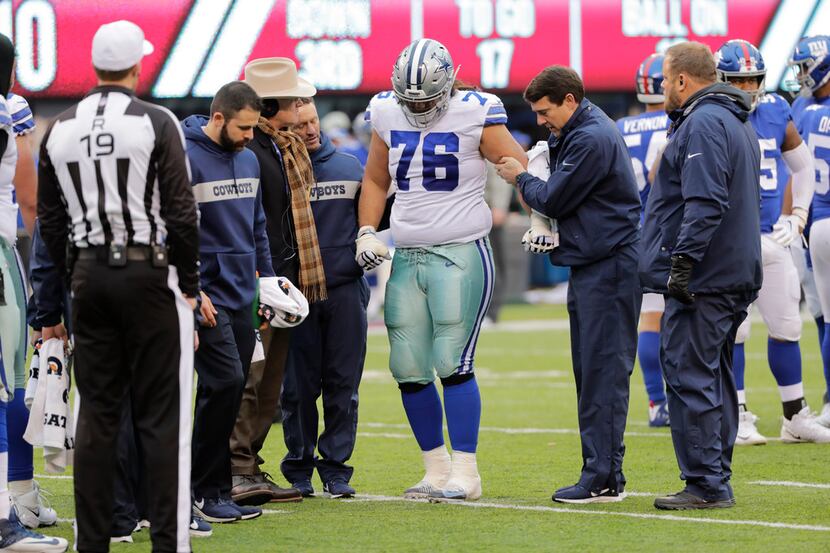 Dallas Cowboys' Xavier Su'a-Filo is helped off the field during the second half of an NFL...