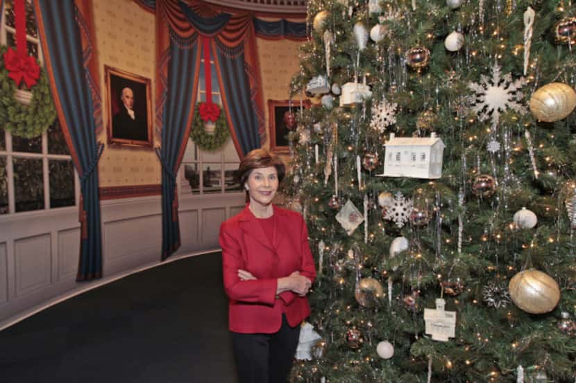 Former first lady Laura Bush stands next to an 18-foot-tall artificial tree that will be...