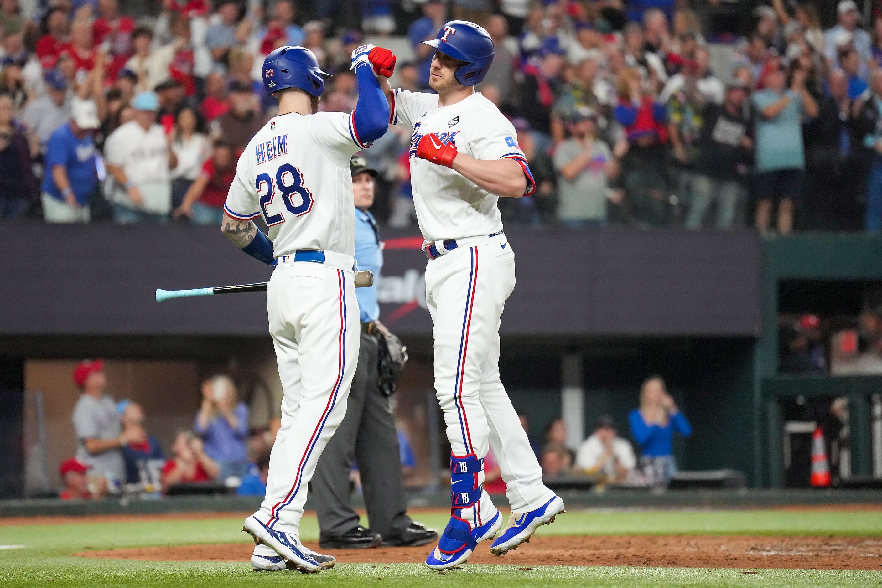 Texas Rangers designated hitter Mitch Garver, right, celebrates with Jonah Heim after hiting...