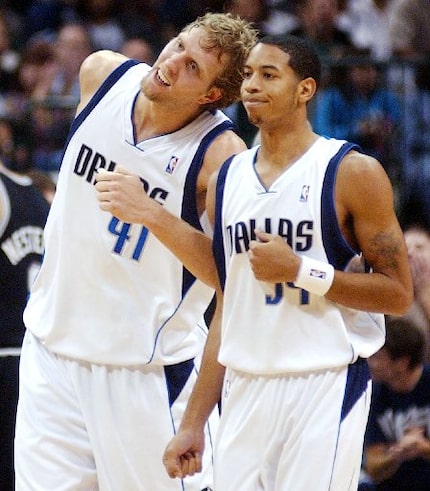 Dallas Mavericks' Dirk Nowitzki (41) of Germany playfully butts heads with Devin Harris (34)...