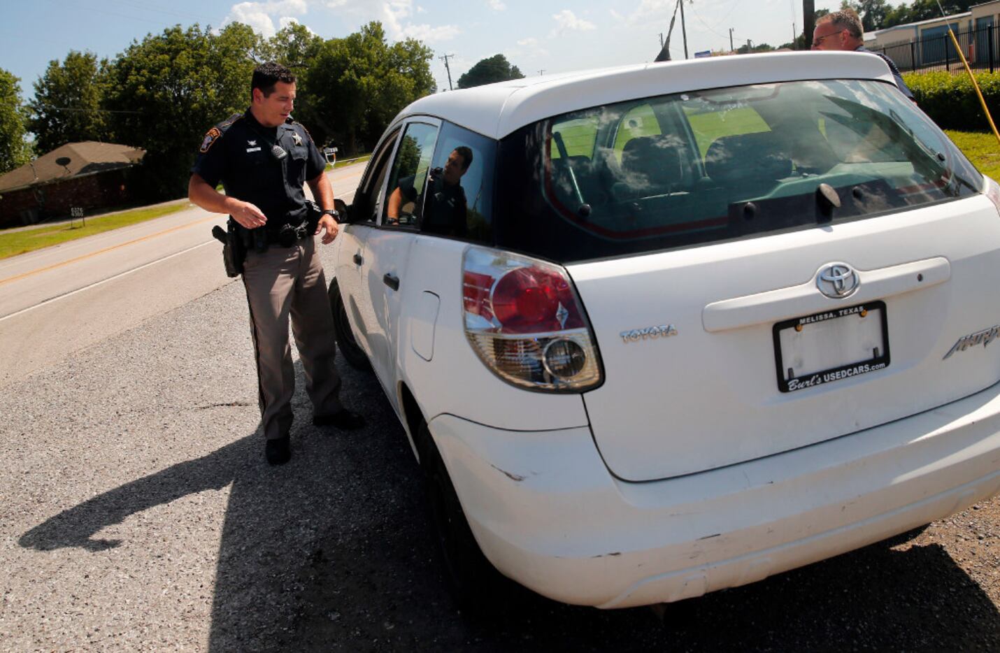 Collin County Sheriff's Deputy Rodney Tackett visits with a driver whose car was missing...