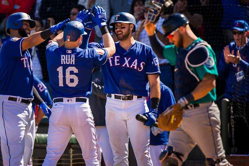 Texas Rangers outfielder Ryan Rua (16, back to camera) celebrates with outfielder Nomar...