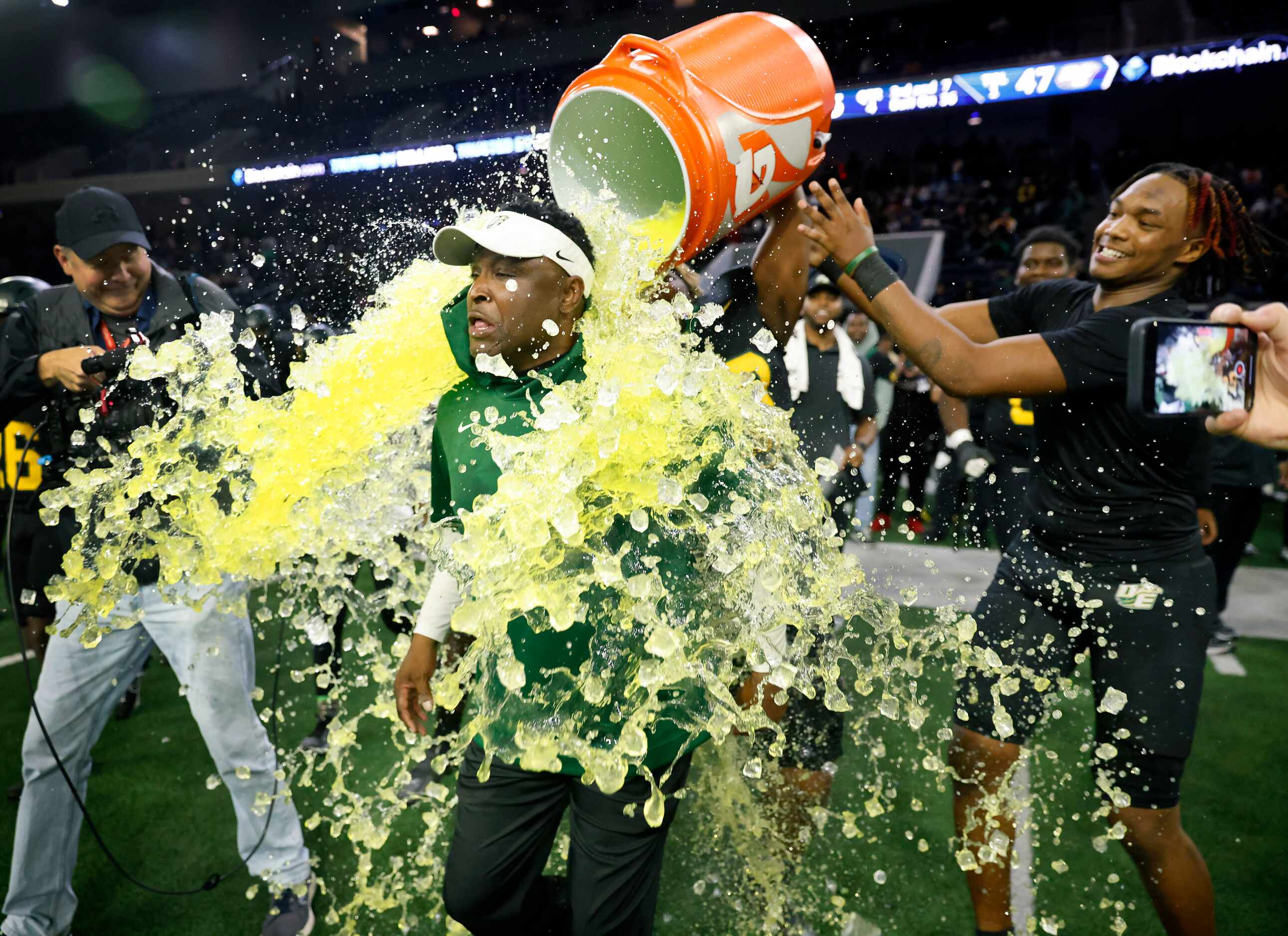 DeSoto head coach Claude Mathis is doused with the Gatorade cooler by his players following...