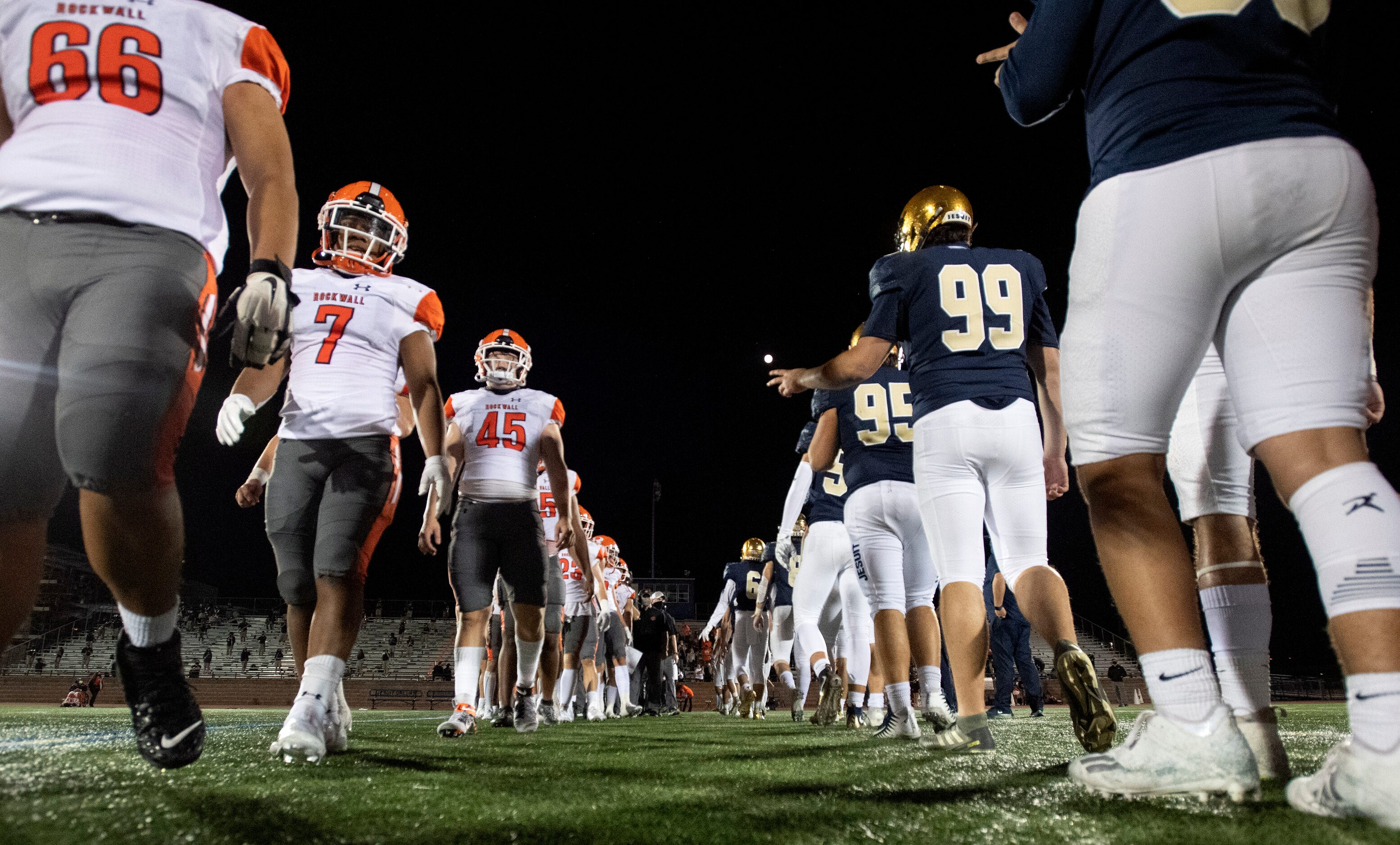 Rockwall and Jesuit players stay five yards apart instead of shaking hands, due to...