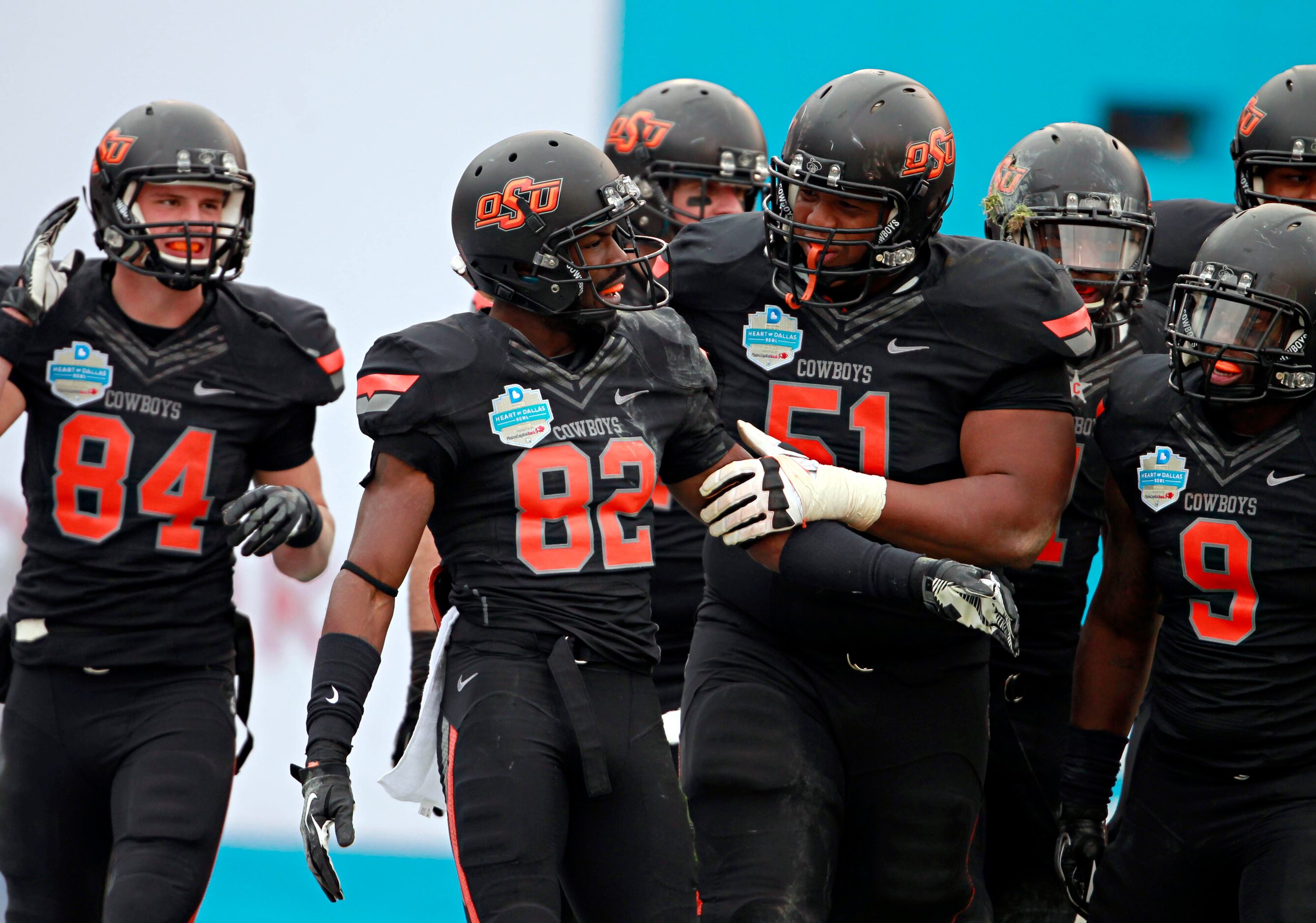 Oklahoma State Cowboys players congratulate wide receiver Isaiah Anderson (82) after he...