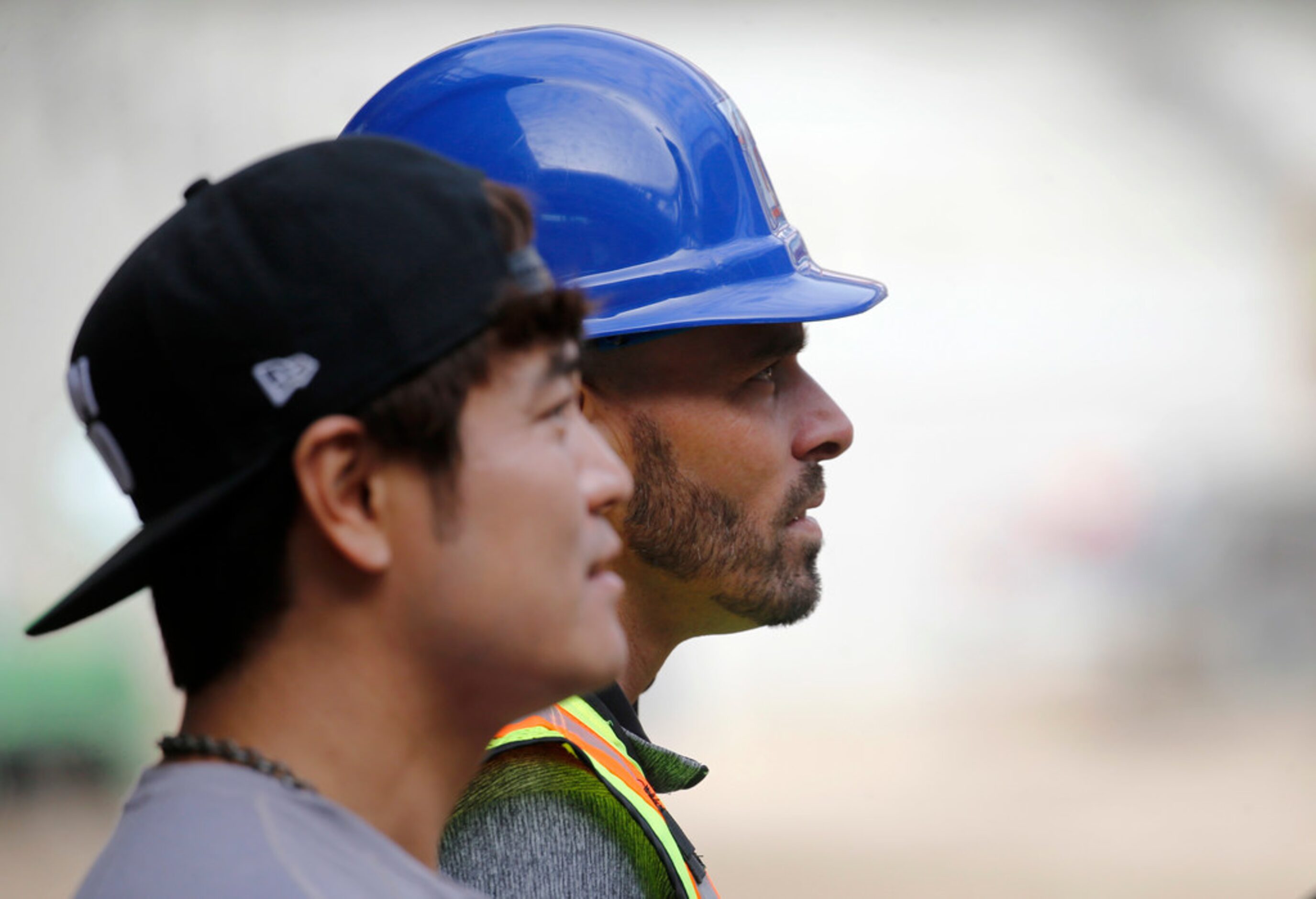 Texas Rangers manager Chris Woodward and Shin-Soo Choo watch as players hit the ball at...