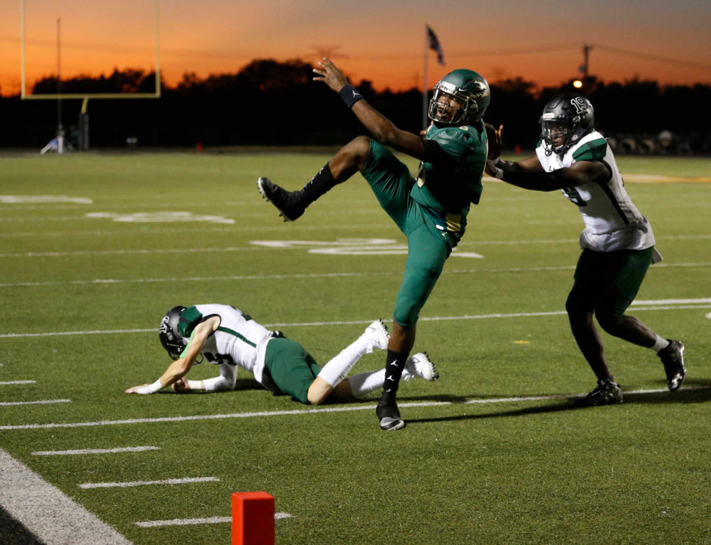 DeSoto Eagles Samari Collier (6) leaps over Mansfield Lake Ridge's Jaxson Lyness (15) as...