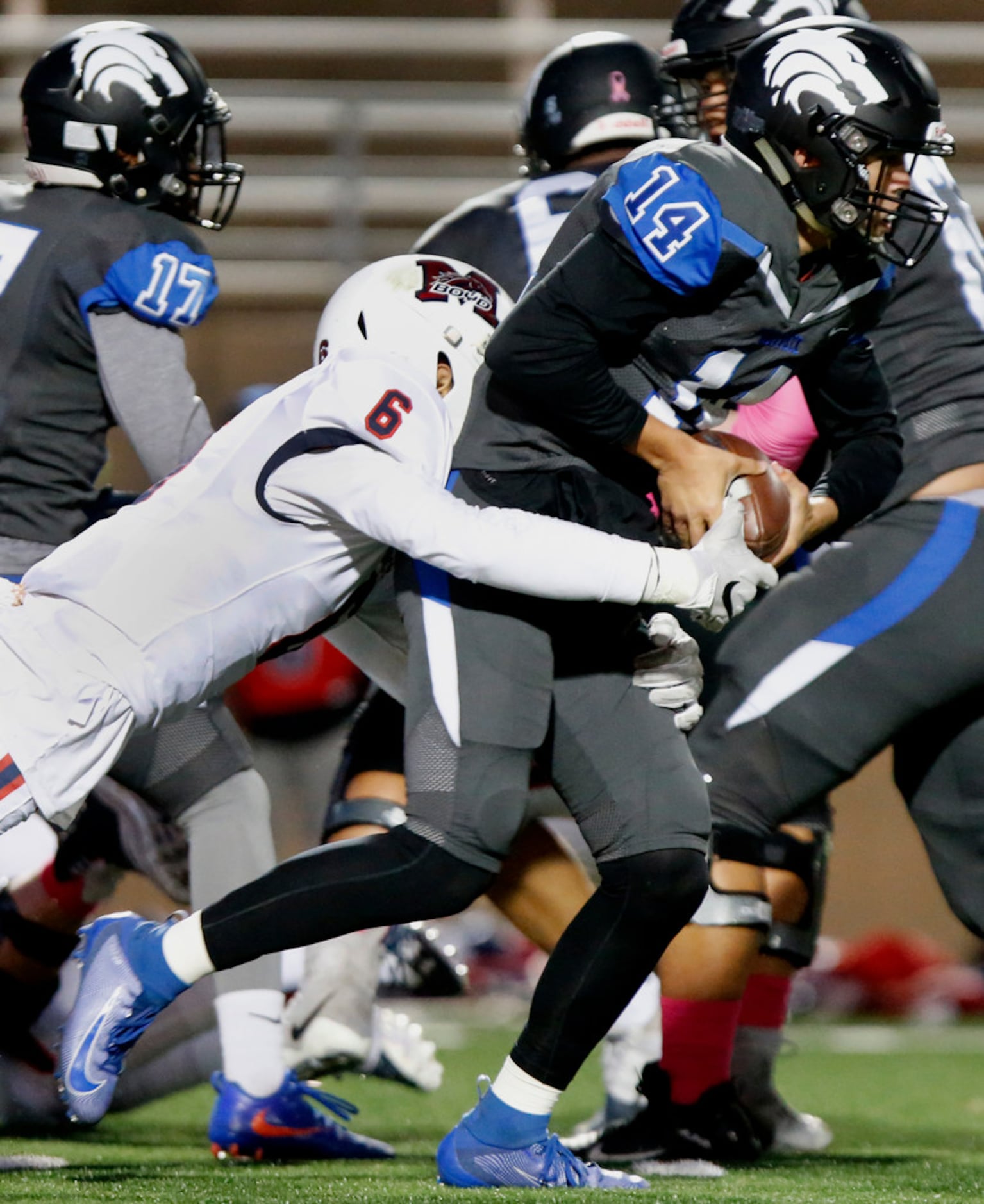 Plano West High School quarterback Andrew Picco (14) is tackled by \mbduring the first half...