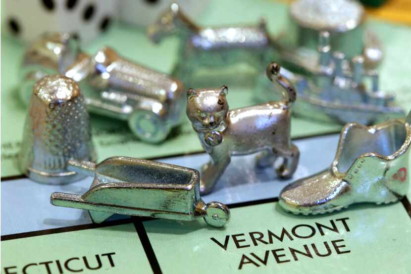 The thimble game piece, left, sits among other Monopoly tokens at Hasbro Inc., headquarters...