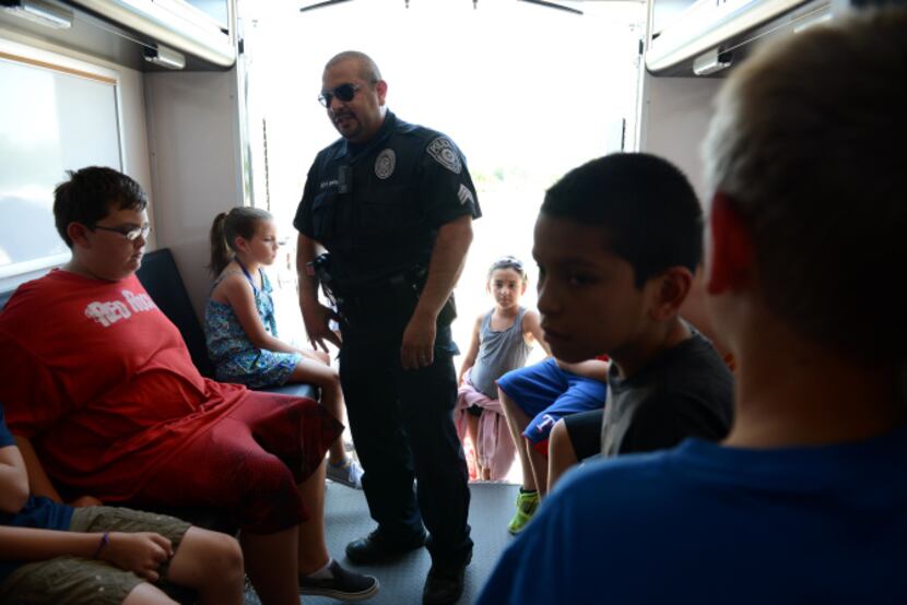 Sgt. Oscar Cantu, of the Rowlett S.W.A.T. team, talks to children inside the tactical truck...
