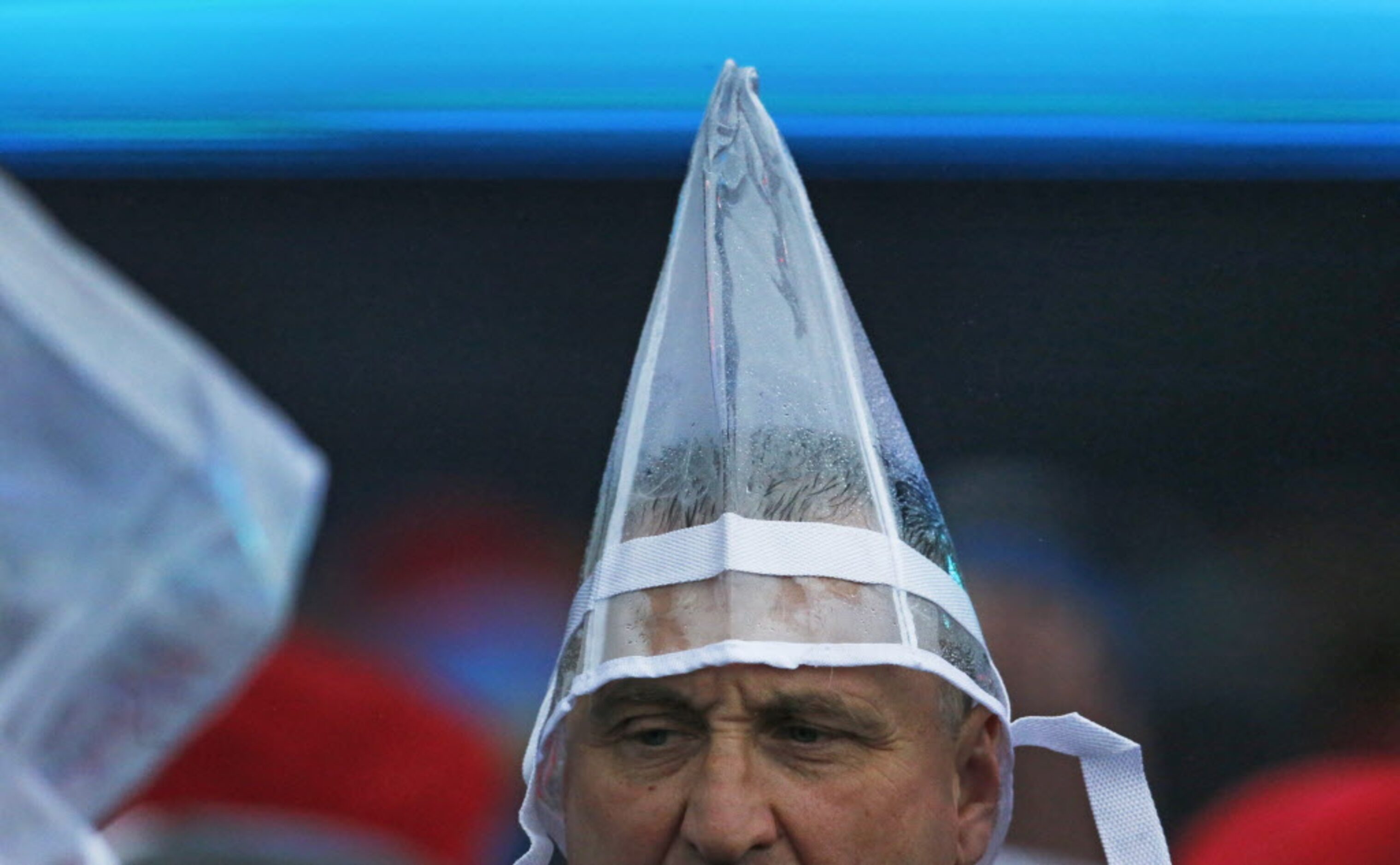 A music fan uses a give-away plastic bag to shield themselves from the rain during the March...