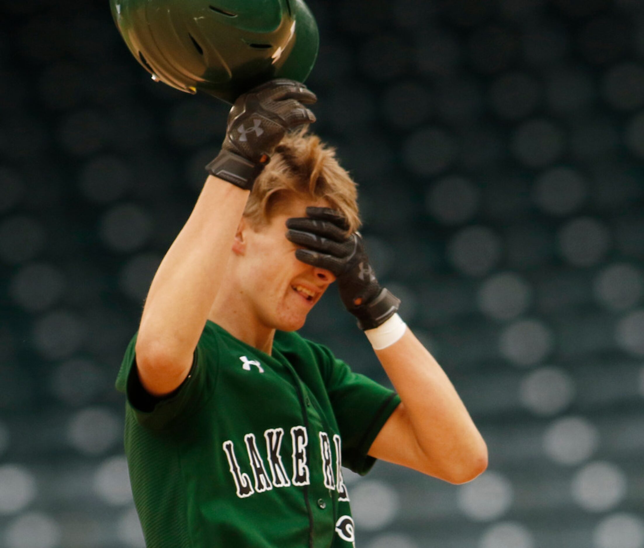 Mansfield Lake Ridge baserunner Kyle Mosley (3) wipes sand from his eyes after safely...