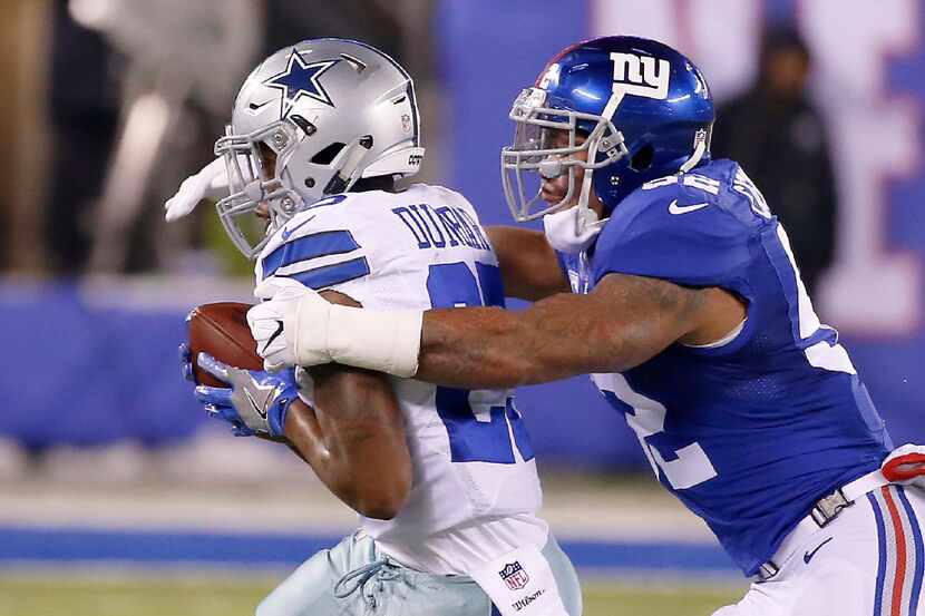 Dallas Cowboys running back Lance Dunbar (25) catches a pass as he's tackled by New York...