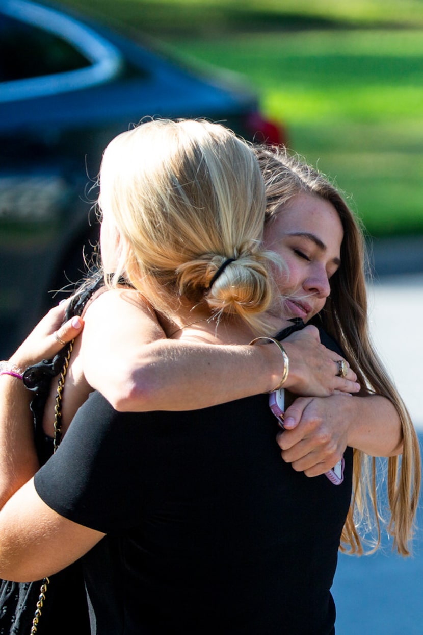 Mourners embrace following Sara Hudson's funeral at Saint Michael and All Angels Episcopal...