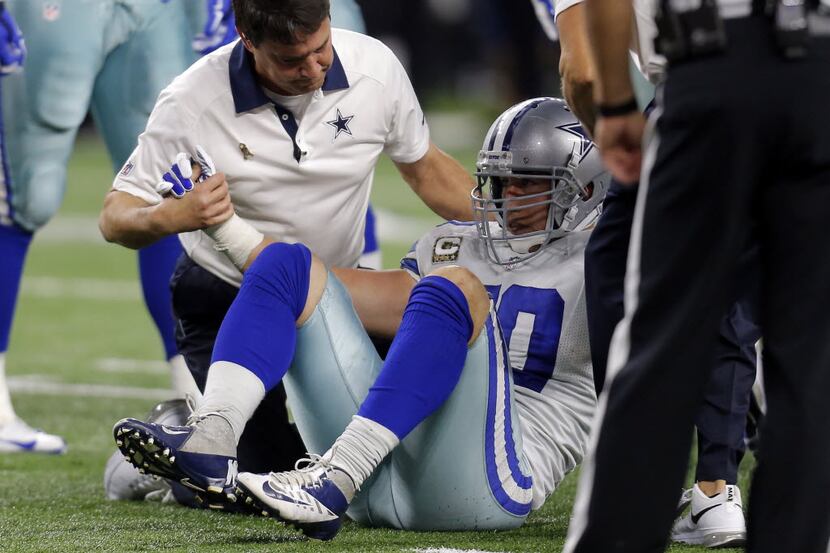 FILE - In this Nov. 8, 2015, file photo, Dallas Cowboys' Sean Lee is assisted by team staff...