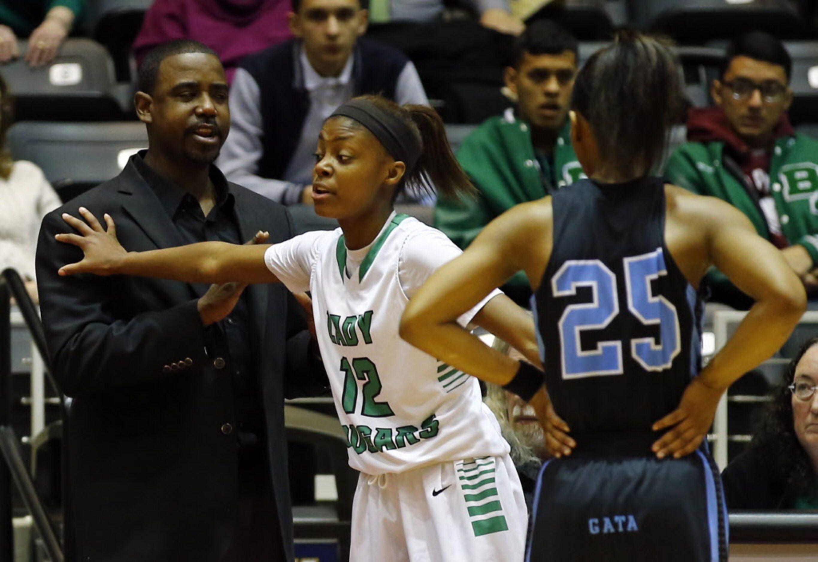 Bryan Adams' Alexxus Gilbert (12) restrains head coach Darren Eubanks as Arlington Seguin's...