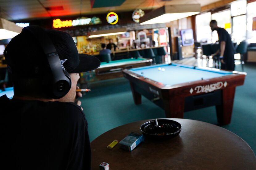 Customers at Rustys Billiards in Arlington smoke and play billiards on Thursday. The city of...