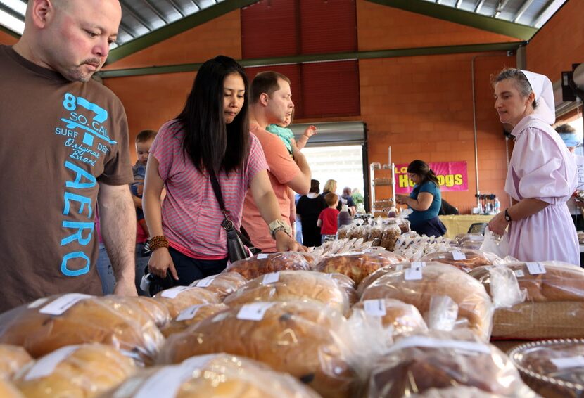 Rebecca Moore, right, of The Country Store Bakery sells breads and pies, as Israel Zapata,...