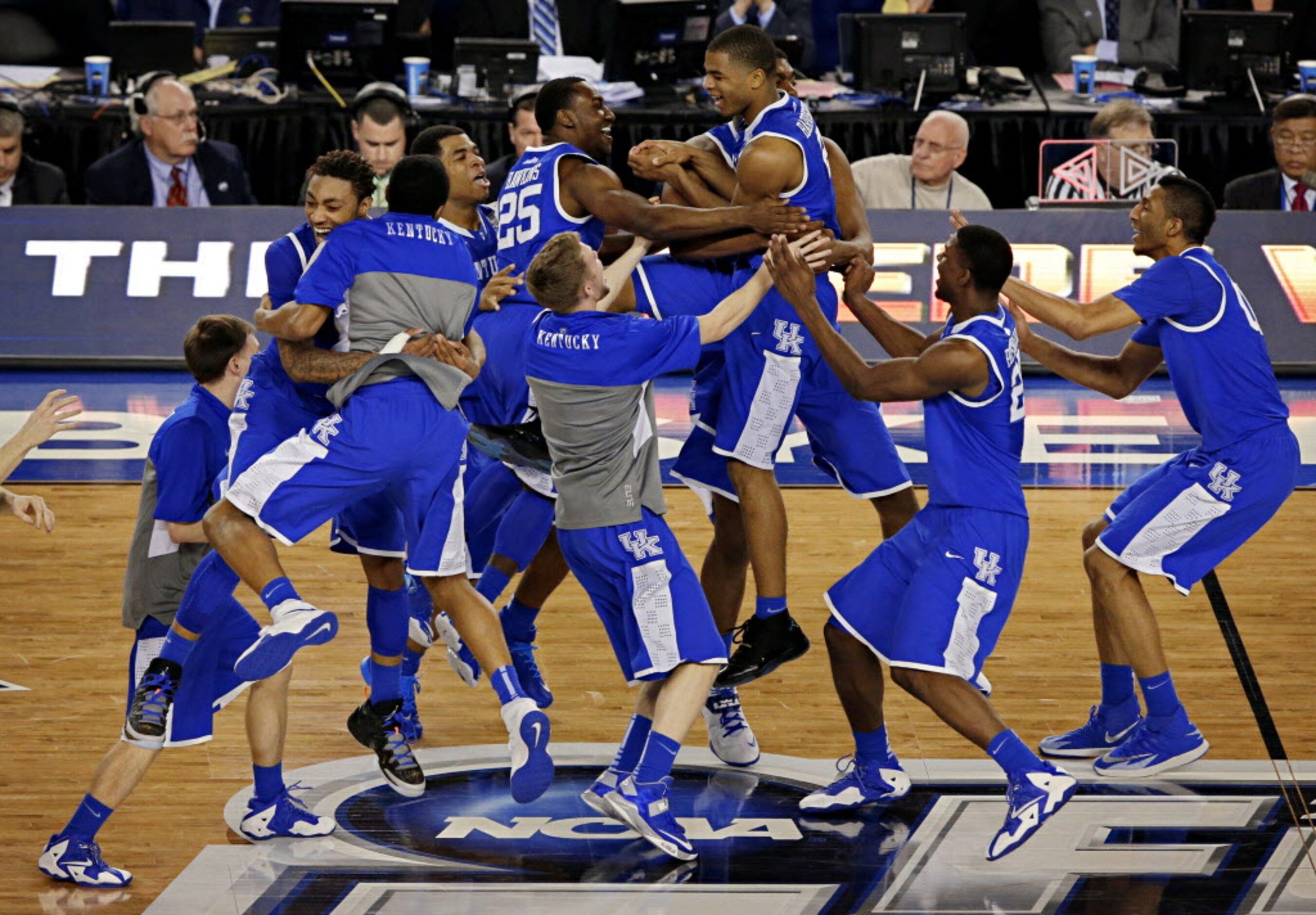 Kentucky Wildcats guard Aaron Harrison (2) is hoisted into the air by jubilating teammates...