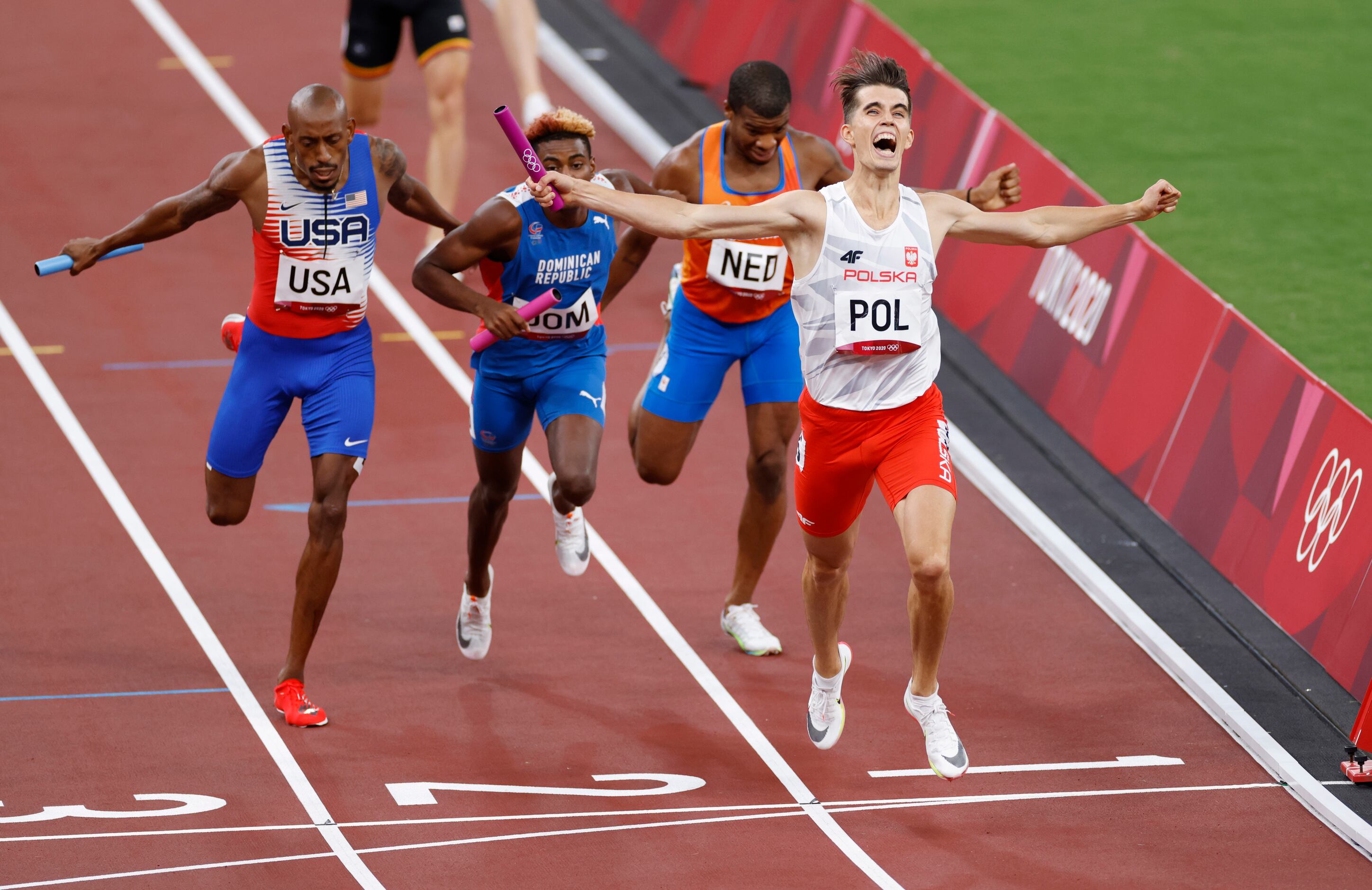 (From l to r) Poland's Kajetan Duszynski celebrates after winning and setting an Olympic...