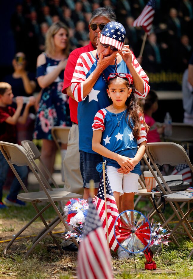 At the foot of her husband's grave, Erlinda Trevino of Mesquite wiped away tears as Taps was...