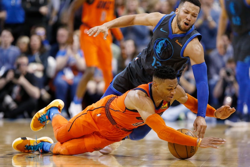 Oklahoma City Thunder guard Russell Westbrook, bottom, dives for a ball in front of Dallas...