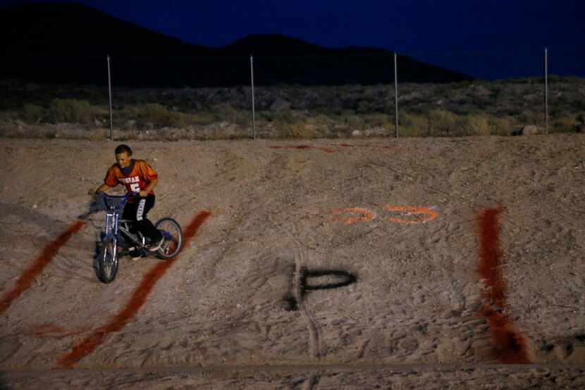 Kobe Bunker, 13, of Tonopah, Nevada, rides a bike on a hill in the football stadium during...