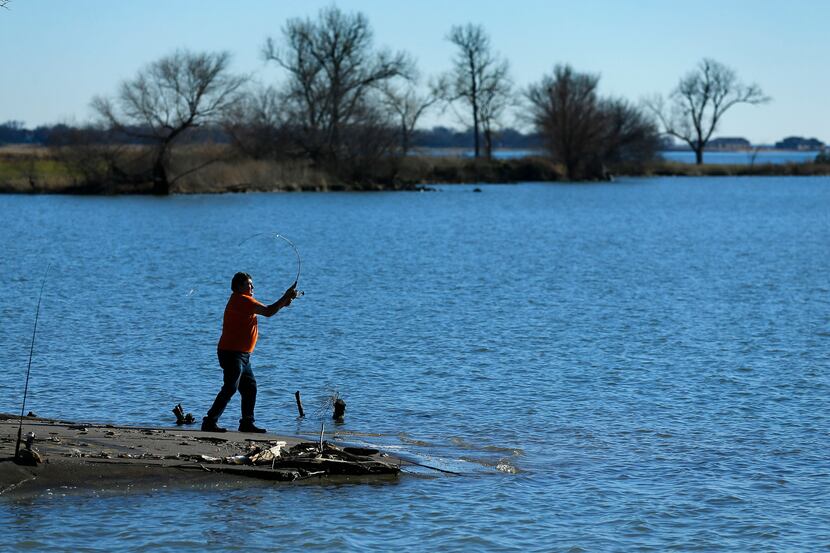 Fisherman Jose J Torres of Dallas cast his line near the Bayside development under...