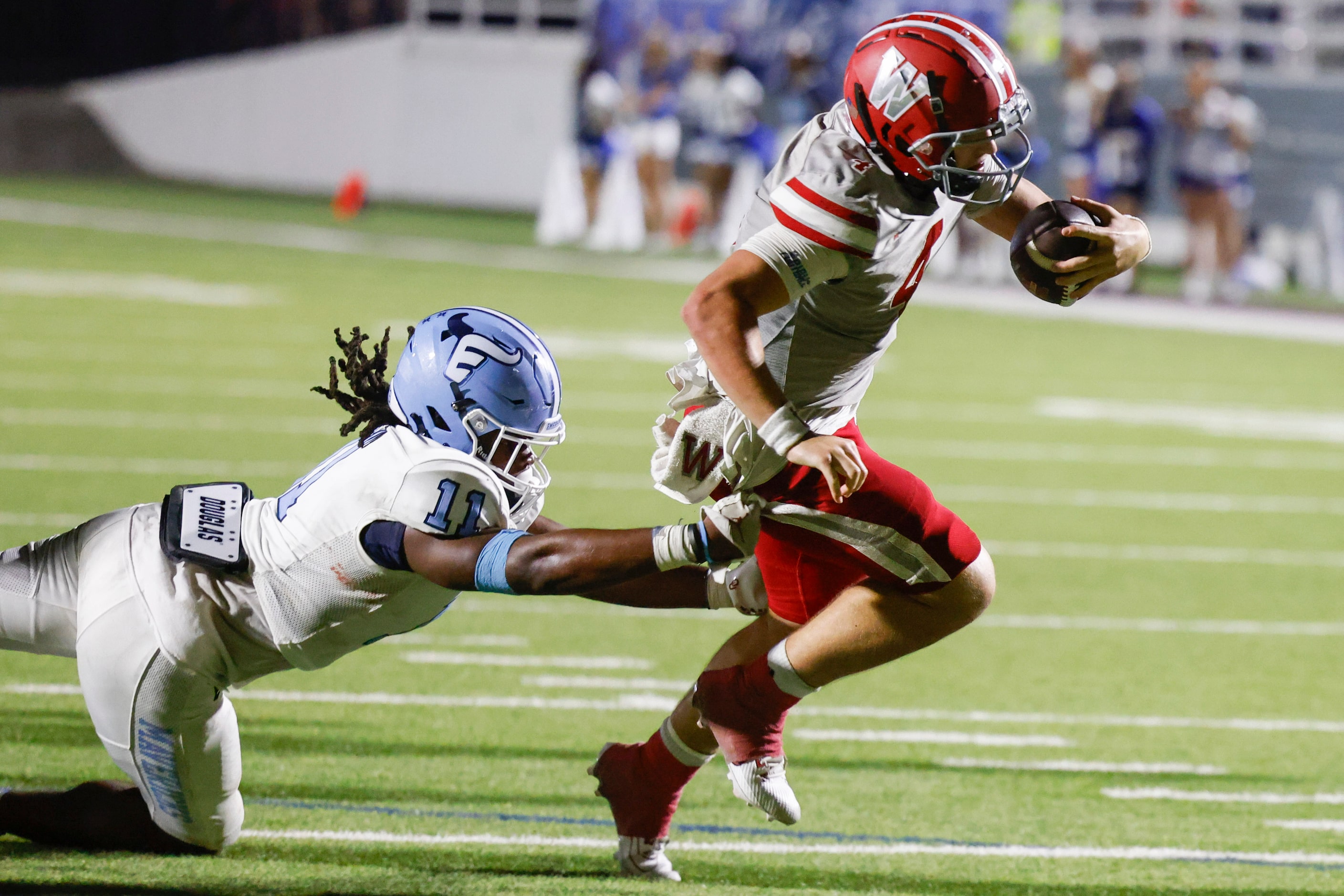 Emerson high’s Agape Lawrence (11) tackles Woodrow Wilson’s QB Cam McGuire as he carries a...