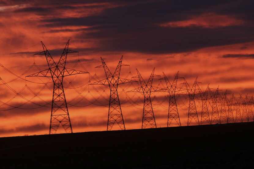 The sun sets on power lines near Sweetwater, Texas, Monday, Dec. 22, 2014. (AP Photo/LM Otero)