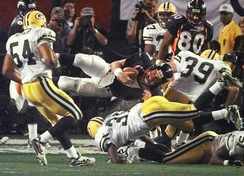 ORG XMIT: S1167675D_WIRE FILE--Denver Broncos quarterback John Elway is upended during the...