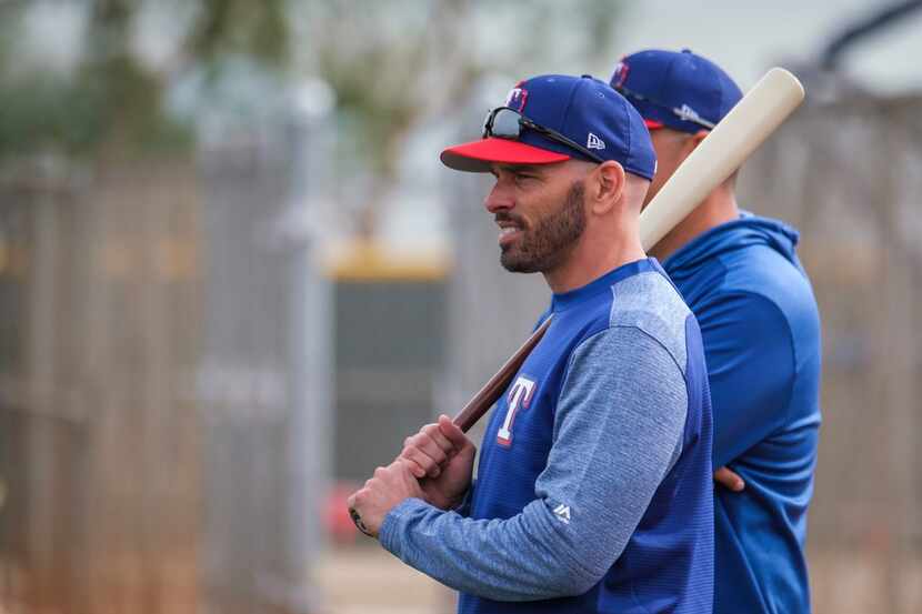 Texas Rangers manager Chris Woodward watches fielding practice during the first pitchers and...