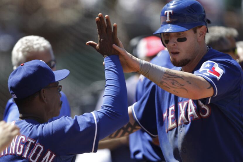 Aug. 13: Josh Hamiltom (right) is congratulated by manager Ron Washington after scoring a...