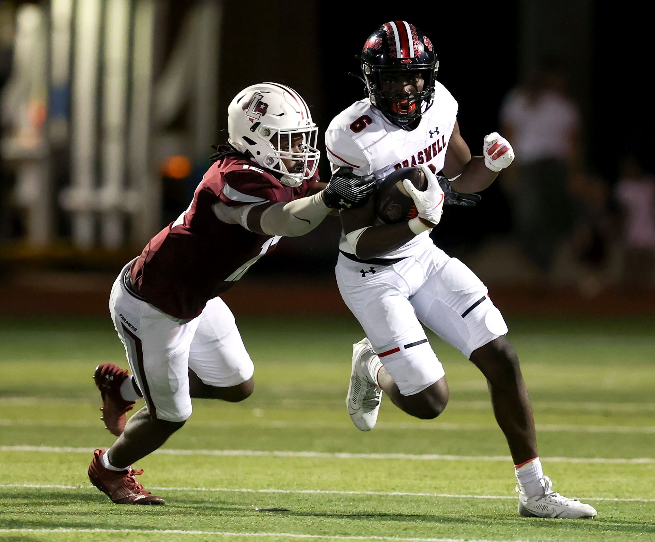 Denton Braswell running back Moses Adelowo (6) tries to fight off Lewisville linebacker...