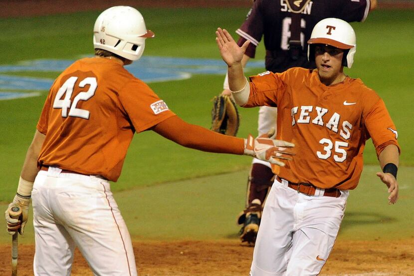 Texas' Madison Carter, right, celebrates his run scored with Kacy Clemens during the seventh...