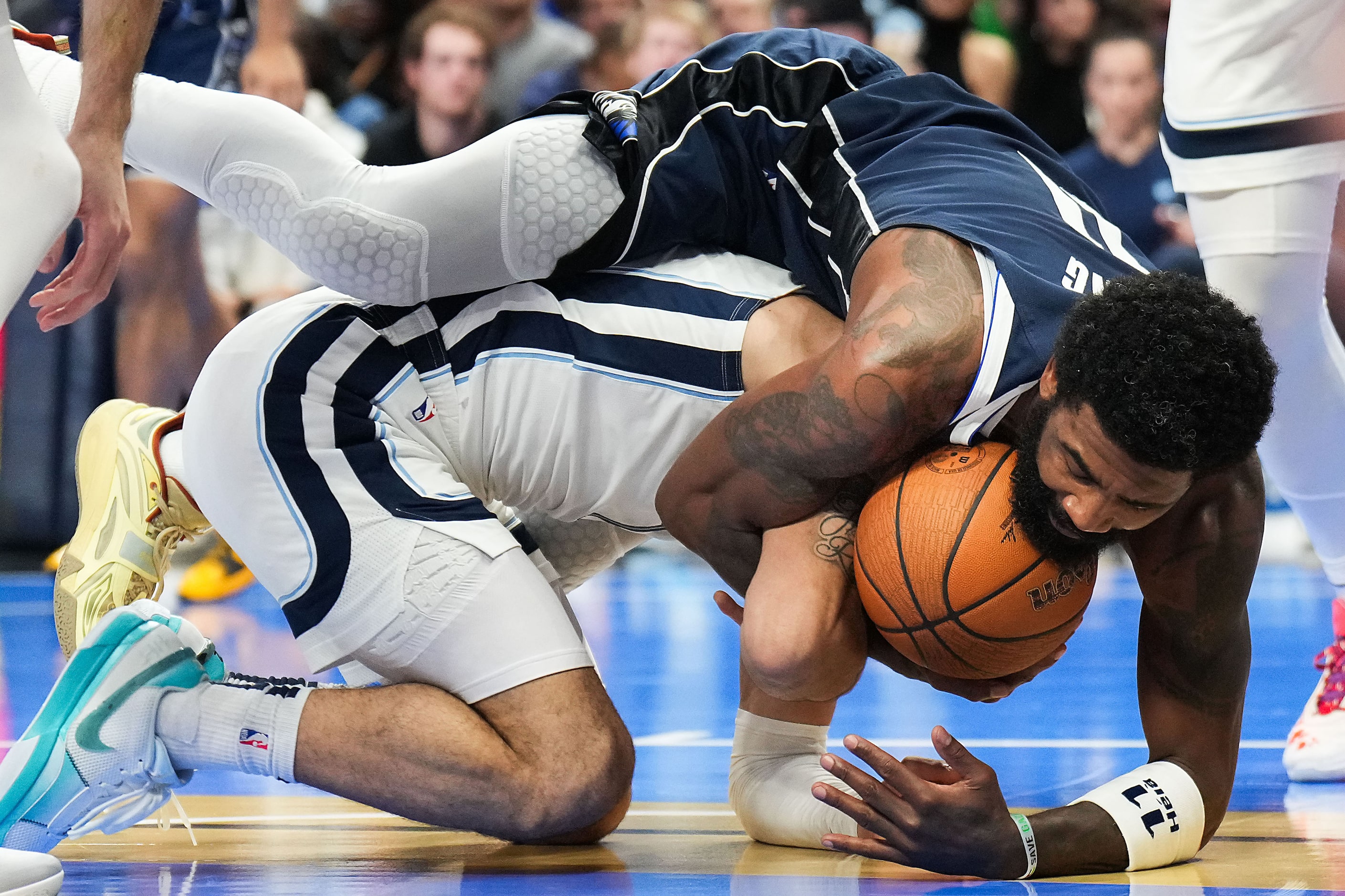 Dallas Mavericks guard Kyrie Irving (11) wrestles for a loose ball with Memphis Grizzlies...